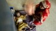 Indian mother fans her child with her sari as the child awaits treatment for diarrhea at a government-run children