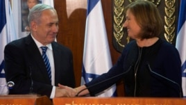 Israel's Prime Minister Benjamin Netanyahu (L) shakes hands with former Foreign Minister Tzipi Livni, head of the centrist Hatenuah party, during their joint statement at the Knesset, the Israeli parliament, in Jerusalem, February 19, 2013.