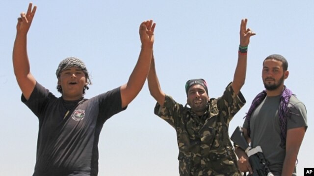 Libyan rebel fighters celebrate as they drive into the coastal city of Zawiyah, August 15, 2011.