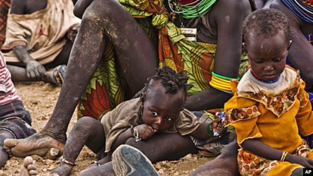 In Kenya, Turkana women and their children wait to receive relief food supplies near the Kakuma Refugee Camp, northwest of Kenya's capital Nairobi, August 8, 2011