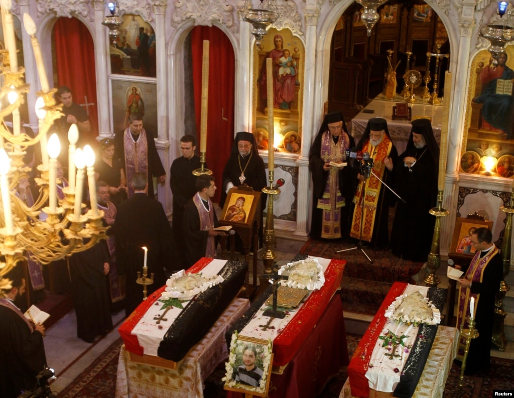 Clerics and other people attend the funeral of three men at Catholic Patriarchate in Damascus, Syria, on September 10, 2013.