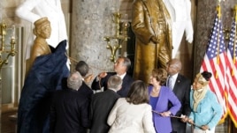 Líderes del Congreso acompañan al presidente Obama en el momento que develan la estatua de bronce.