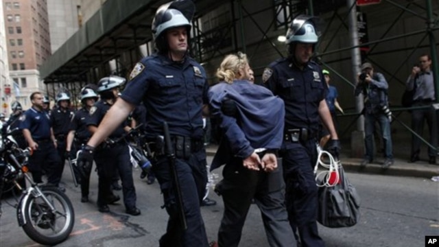 Police officers take away a protester during an Occupy Wall Street march at the New York Stock Exchange in Manhattan, Sept. 17, 2012.