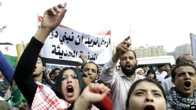 Syrian protesters shout anti-Assad slogans during a protest in front of the Arab League headquarters in Cairo, Egypt,  November 12, 2011.