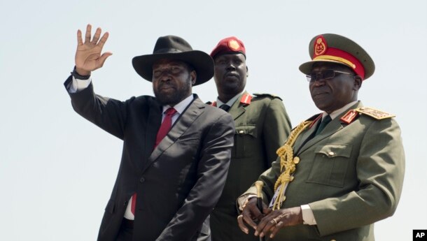South Sudan's President Salva Kiir, left, accompanied by army chief of staff Paul Malong, right, waves during an independence day ceremony in the capital Juba, South Sudan.