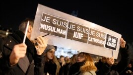 People hold a placard which reads "I am Muslim, I am Jewish, I am Catholic, I am Charlie" at a vigil, following the shooting at the satirical newspaper Charlie Hebdo, Jan. 8, 2015.