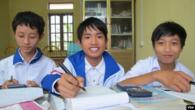 Three school children use books borrowed from one of Thach's parental libraries at An Duc secondary school, Thai Binh province, Vietnam, November 24, 2012. (M. Brown/VOA)               
