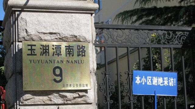 A blue sign taped up to the fence next to the address plaque sign warns reporters that people in this residential compound do not accept interviews.  Liu Xia, the wife of the newest Nobel Peace Laureate Liu Xiaobo, lives inside and is reportedly under hou