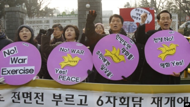 Anti-war activists attend a rally opposing South Korea's planned firing drill on Yeonpyeong Island, in front of the defense ministry in Seoul, 20 Dec, 2010.