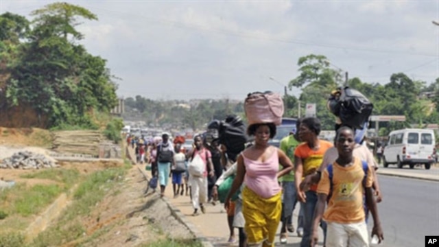 Residents of the popular district of Abobo, a suburb of Abidjan, flee fighting on February 25, 2011