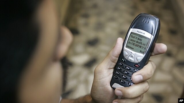 A Pakistani man with his mobile phone containing a prank message, Karachi, April 2007 (file photo).