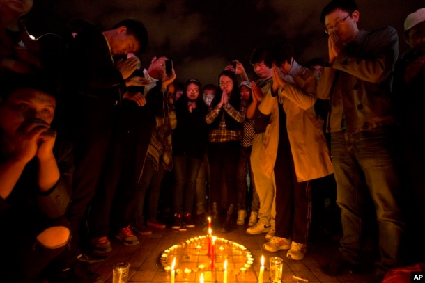 2014年3月2日，人们在昆明火车站外的一个广场为暴徒砍人事件的死难者祈祷