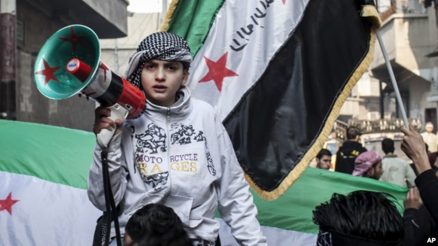 Syrian youth with megaphone leads rally supporting the Free Syrian Army in the Aleppo's Bustan al-Qasr district, January 4. (AP)