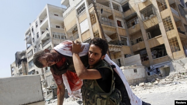 Free Syrian Army fighter carries body of fellow fighter during clashes in Aleppo, August 16, 2012. 