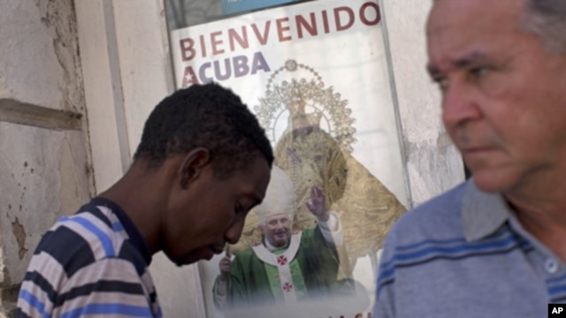 A poster showing Pope Benedict XVI, the Virgin of Charity of Cobre, Cuba's patron, is displayed on a window in Santiago de Cuba, Cuba, Sunday, March. 25, 2012. 