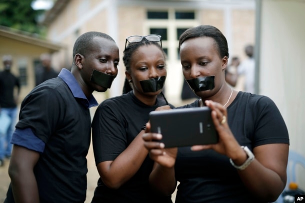 FILE - Journalists with tape on their mouths gather on the occasion of World Press Freedom Day, Bujumbura, Burundi, May 3, 2015.