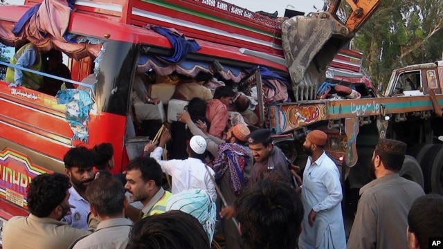 Nhân viên cứu hộ Pakistan giúp đưa hành khách ra khỏi chiếc xe khách bị đâm nát tại Pannu Aqil, ngày 20/4/2014.