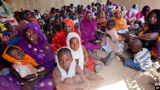 Women and children wait to participate in a vaccination campaign against meningitis at the community center in Al Neem camp for Internally Displaced People in El Daein, East Darfur, Sudan, October 8, 2012.