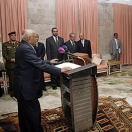 Yemen's newly appointed Prime Minister Mohammed Salem Basindwa (front L) takes the oath of office at the Republican Palace in Sana'a, December 10, 2011.