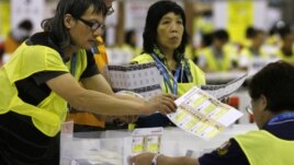 Electoral officers count ballots at the central ballot counting station after legislative elections in Hong Kong, Monday, Sept. 10, 2012.