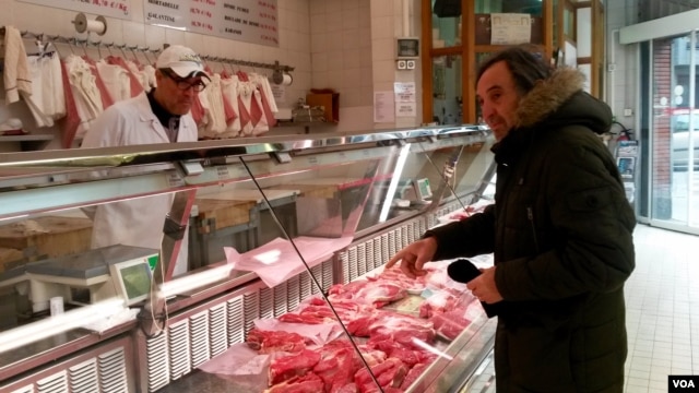 Butcher Abdel Haq takes a question from a customer at Boucherie de l'Argonne, in Paris, Feb. 3, 2016. ( L. Bryant/VOA)