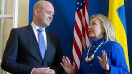 Swedish Prime Minister Fredrik Reinfeldt, left, greets US Secretary of State Hillary Rodham Clintonas she arrives for meetings at Rosenbad in Stockholm, Sweden, Sunday, June 3, 2012.