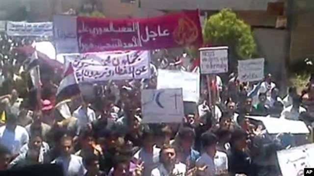 An image taken from YouTube shows Syrian anti-regime protesters marching during a rally in the northeastern city of Kafr Nabl, June 3, 2011