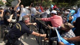 Cảnh sát chống bạo động sử dụng bình xịt hơi cay để đẩy lùi một nhóm biểu tình Uighur bên ngoài Đại sứ quán Trung Quốc tại Thổ Nhĩ Kỳ. (AP Photo/Burhan Ozbilici)