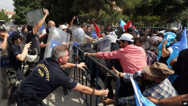 Cảnh sát chống bạo động dùng hơi cay để đẩy lùi một nhóm người Uighur biểu tình đang cố phá rào bên ngoài Đại sứ quán Trung Quốc ở Ankara, Thổ Nhĩ Kỳ, 9/6/2015.