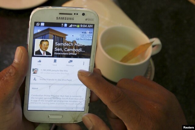 FILE - A person uses a smartphone to look at the Facebook page of Cambodia's Prime Minister Hun Sen during breakfast at a restaurant in central Phnom Penh, Cambodia, Oct. 7, 2015.