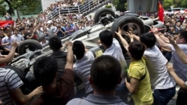 Protesters overturn a Japanese-brand police car during an anti-Japan protest in Shenzhen, Guangdong province, August 19, 2012.