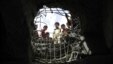 FILE - Boys look through a hole made by a Saudi-led airstrike on a bridge in Sanaa, Yemen, March 23, 2016. 