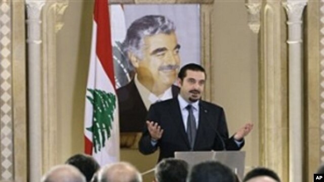 Lebanese caretaker Prime Minister Saad Hariri speaks during a press conference with a poster of his slain father Rafik Hariri in the background, in Beirut,  Jan. 20, 2011