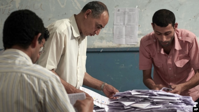 Egyptian election workers count the ballots following the end of the two day presidential election at a school in Cairo, Egypt. Experts say the elections were fairly clean given Egypt's past corruption.