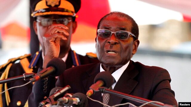 Zimbabwean President Robert Mugabe gestures as he addresses mourners gathered for the burial of Vice-President John Nkomo at National Heroes Acre, in Harare, Zimbabwe, January 21, 2013.