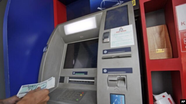 A man uses an ATM machine at KBZ bank's head office in Rangoon, March 14, 2012. 