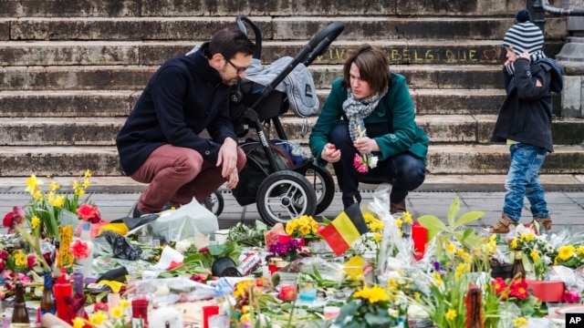 Một gia đình thắp nến cầu nguyện tại khu tưởng niệm Place de la Bourse ở Brussels, ngày 27/3/2016.