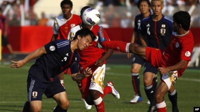 Shiji Okazaki, kiri, menyundul bola dan berhasil menyarangkan gol selagi Rashid Alfarsi berusaha menggagalkannya. Gol pada menit-menit terakhir itu membuat Jepang menang 2-1 atas Oman (foto, 11/14/2012).  