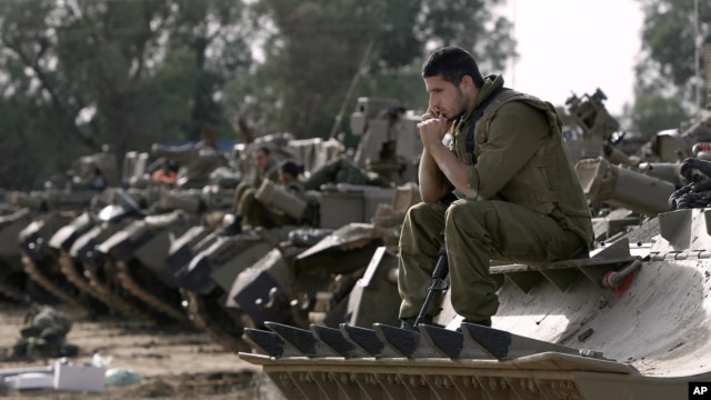 Israeli soldiers with armored vehicles gather in a staging ground near the border with Gaza Strip, southern Israel, Friday, Nov. 16, 2012. 