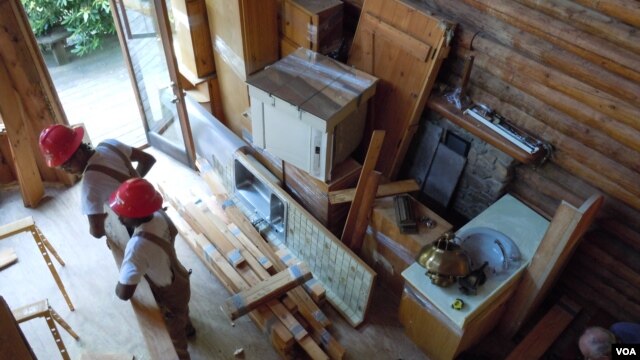  Workers from Second Chance remove all usable material from a log cabin scheduled to be torn down. (J. Taboh/VOA)         