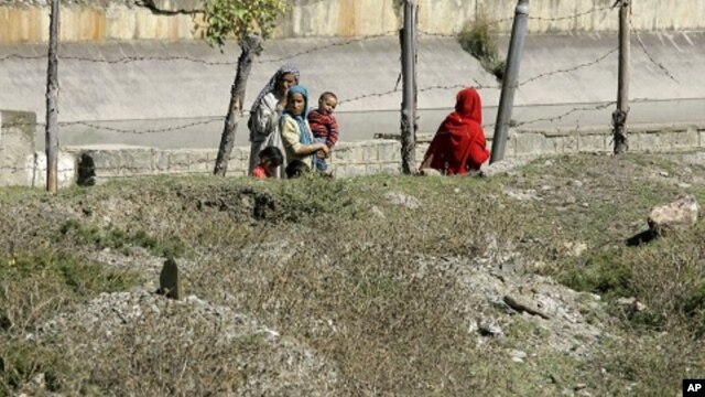 Kashmiri villagers walk past a graveyard containing unidentified dead at Bimyar, about 60 miles (96 kilometers) west of Srinagar, India (File Photo)