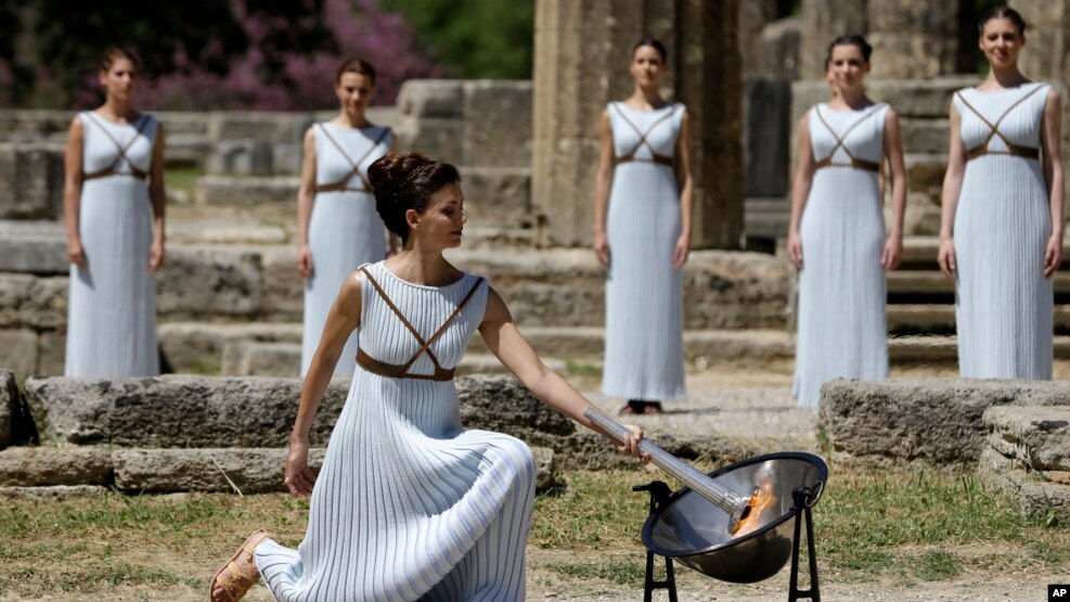 La llama olímpica fue encendida por la actriz Katerina Lehou, representando una suma sacerdotisa pagana, el miércoles 20 de abril de 2016, en la Antigua Olimpia, Grecia. Actress Katerina Lehou, right, as high priestess, lights the Olympic Flame, during the final dress rehearsal of the lighting of the Olympic flame at Ancient Olympia, in western Greece, April 20, 2016.