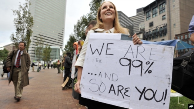 A woman who identified herself only as Jenna, and said she worked at an architecture firm in Boston's financial district, stops on her way to work to join demonstrators with Occupy Boston on Monday, Oct. 3, 2011.