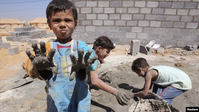 Syrian refugee children play with clay after workers end work at Al Zaatri refugee camp in the Jordanian city of Mafraq, near the border with Syria, September 2, 2012.
