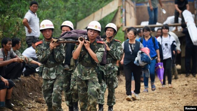 Nhân viên cứu hộ khiêng người bị thương trên cáng tại thị trấn thị trấn Long Đầu Sơn của huyện Lư Điền, ngày 4/8/2014.