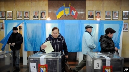 A woman casts her ballot at a polling station during the Crimean referendum, in Sevastopol, Ukraine, Sunday, March 16, 2014.