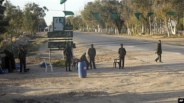 In this image taken during a trip organized by Libyan authorities, Libyan soldiers control a checkpoint near the city of Misrata, April 9, 2011