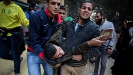 A protester wounded in clashes with security forces is evacuated from the site in the Mohandiseen district of Cairo, Egypt, Saturday, Jan. 25, 2014.