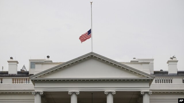A U.S. flag is seen at half-staff over the White House in Washington, Friday, July 20, 2012. President Barack Obama ordered the flag to be lowered in the aftermath of the tragic mass shooting at a movie theater in Aurora, Colorado.