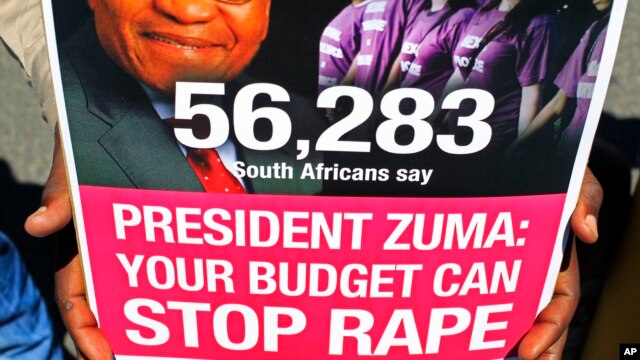 A man holds a poster during a protest against violence toward woman, before South African Finance minister Pravin Gordhan gave his budget speech at Parliament in Cape Town , South Africa, Feb. 27, 2013.